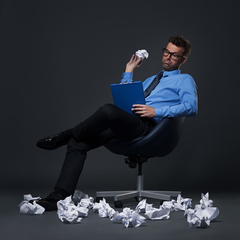 Un'azienda paperlass adotta sistemi di archiviazione digitale dei documenti per ridurre la quantità di carta e ottimizzare i costi aziendali. Nella foto un dipendente d'ufficio che getta cartacce sul pavimento.