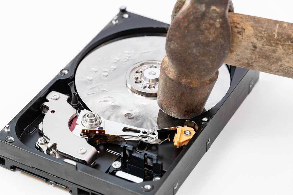 Prevenire il danneggiamento dell&apos;hard disk può salvarti dall&apos;incubo di un&apos;improvvisa perdita di dati. Nella foto, un disco rigido che viene danneggiato con un martello.