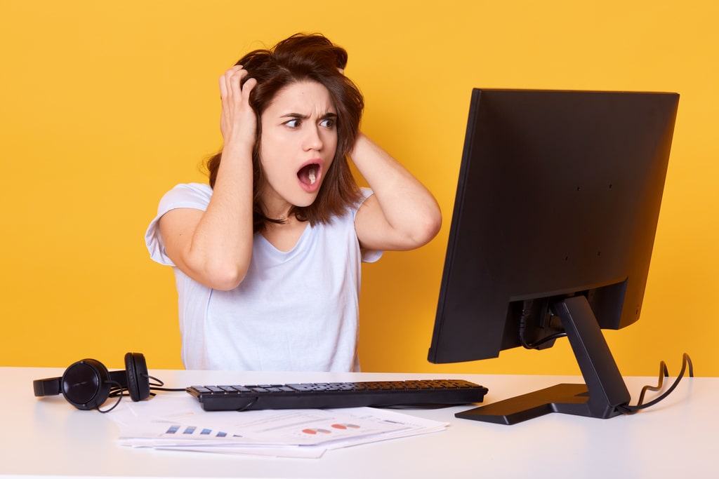 Per prevenire il danneggiamento dell'hard disk del proprio computer, è molto importante adottare alcuni comportamenti che possano metterci in guardia da eventuali danni e guasti improvvisi. Uno dei primi segnali è il rallentamento e il malfunzionamento del proprio dispositivo: nella foto, una donna disperata per un guasto al proprio pc.